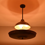 Copper disc chandelier casting warm ambient indirect lighting, creating a soft glow across the ceiling