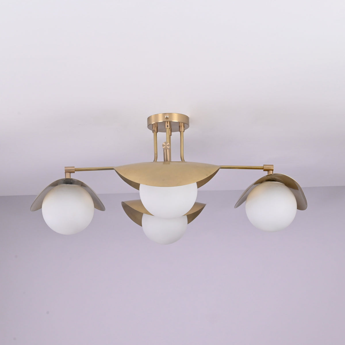 Curva 4-light brushed brass flush mount ceiling light with curved bowl shades and opal globe diffusers, handcrafted by Brass Leaf Studio.