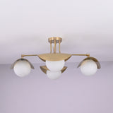 Curva 4-light brushed brass flush mount ceiling light with curved bowl shades and opal globe diffusers, handcrafted by Brass Leaf Studio.