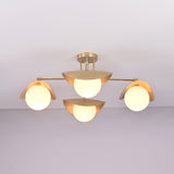 Lit front view of Curva brass flush mount featuring warm ambient glow, curved brass shades, and minimalist globe design.