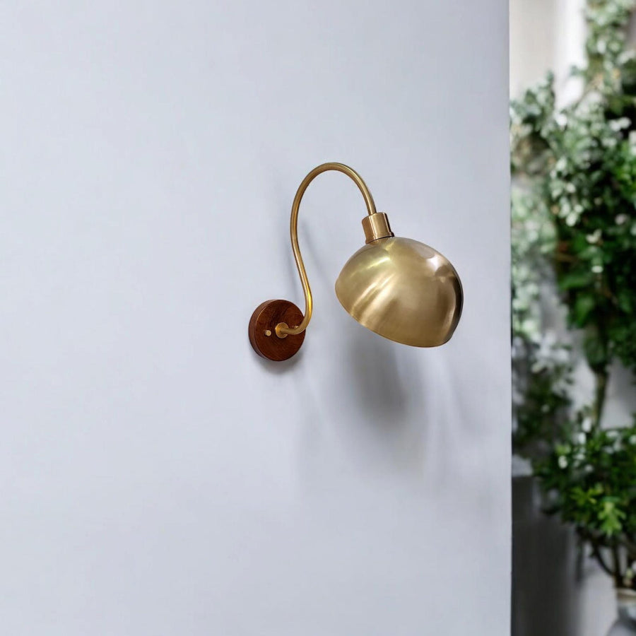 Handmade brass wall sconce with curved arm and dome shade – front view