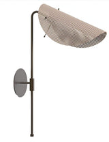 Curved brass wall lamp with perforated metal shade photographed on white background