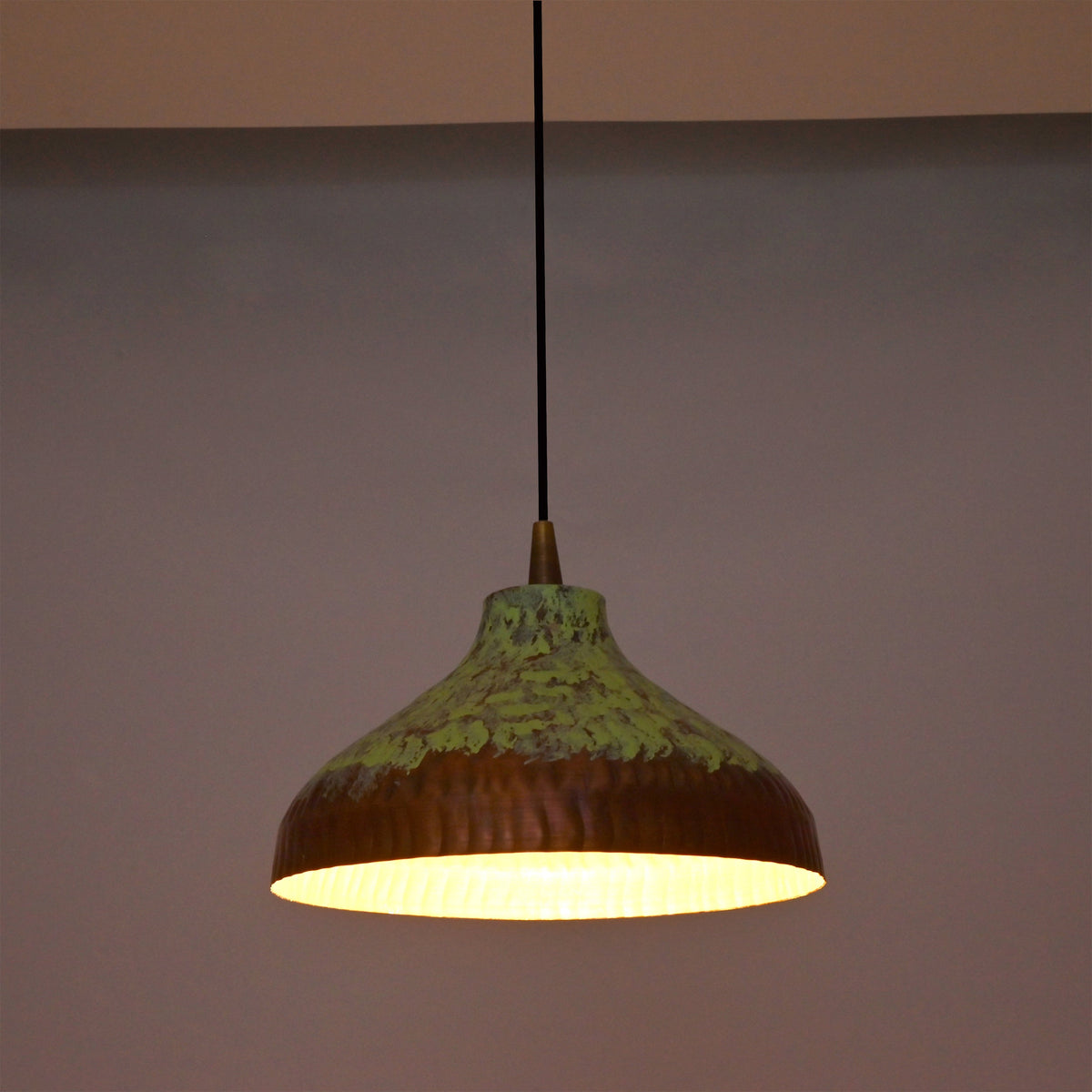 Custom copper pendant light with black cord, copper canopy, and green patina dome shade for modern rustic interiors