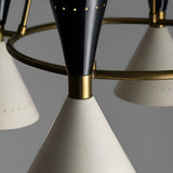 Detail view of Diabolo chandelier showcasing perforated cone shade, brass ring frame, and warm interior glow