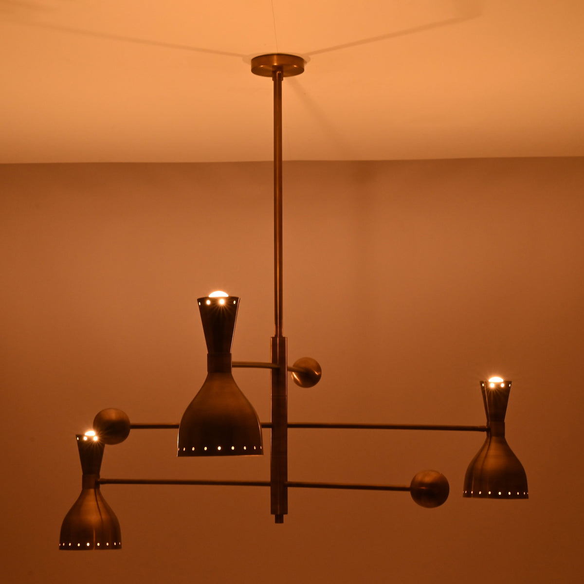 Artistic angle of Diabolo designer brass chandelier highlighting geometric balance, premium craftsmanship, and atmospheric lighting.