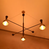 Diabolo industrial-style brass chandelier enhancing interior ambiance with sculptural form and warm handcrafted lighting.