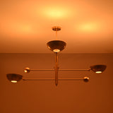 Disc style brass chandelier illuminated with warm ambient indirect lighting