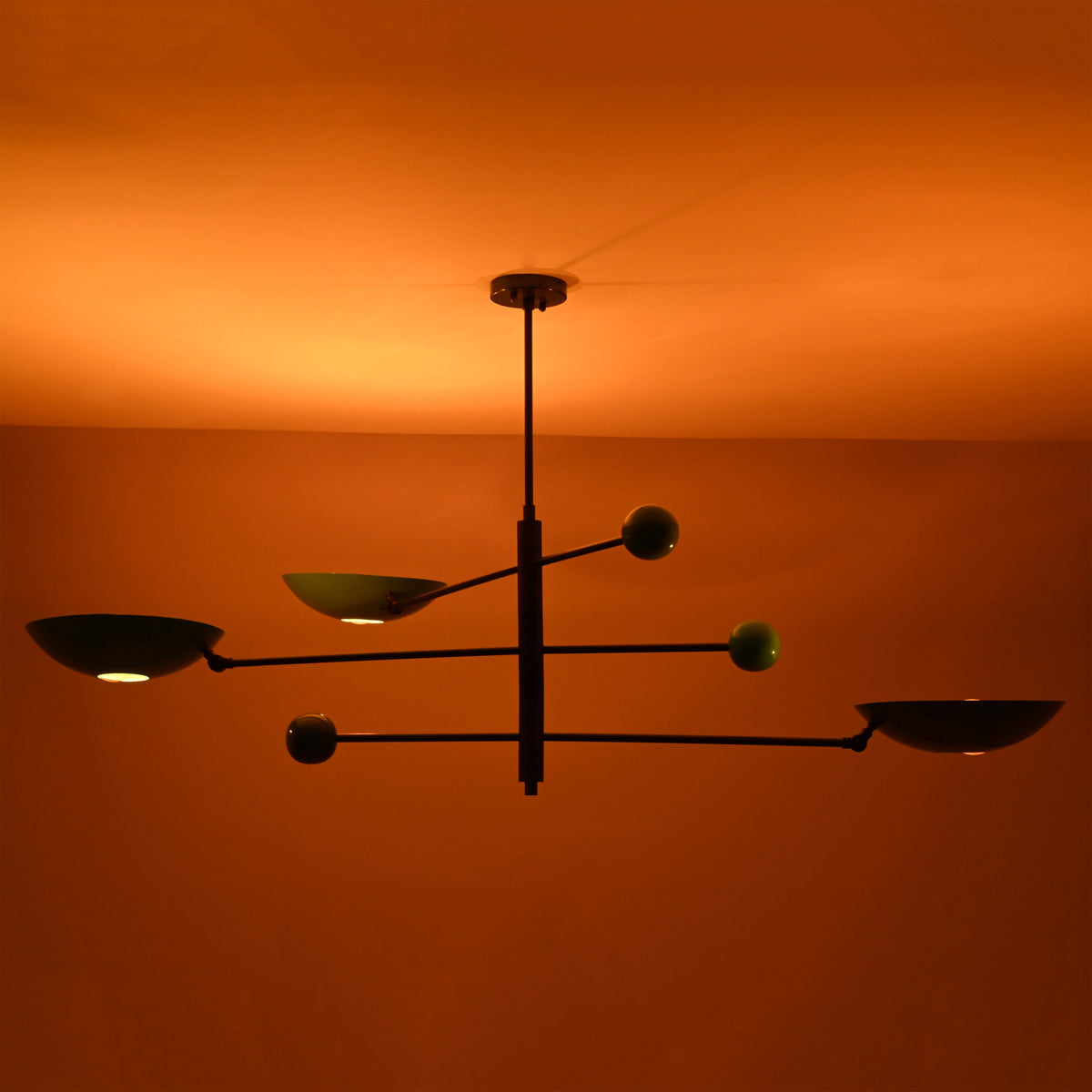 Disc chandelier creating soft indirect light patterns across the ceiling in a warm interior