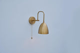 Dome-shaped brass wall light with minimal silhouette and pull chain, handcrafted in India by Brass Leaf Studio.