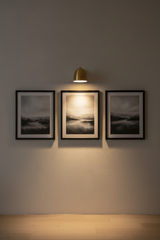 A modern dome-shaped wall sconce in a brushed brass or gold finish, shown against a plain white background.