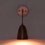 Front view of the Hudson Modern Hammered Copper Cone Wall Sconce mounted on a wall with warm downward illumination, showcasing the handcrafted hammered copper cone shade and minimalist design.