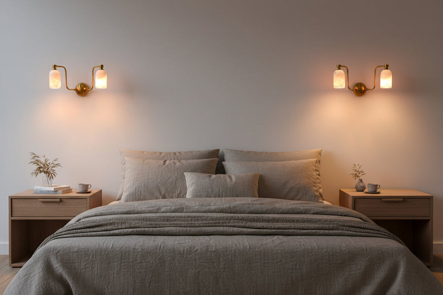 Dual alabaster cylinder wall light with curved brass arms and round brass patina canopy for elegant interiors