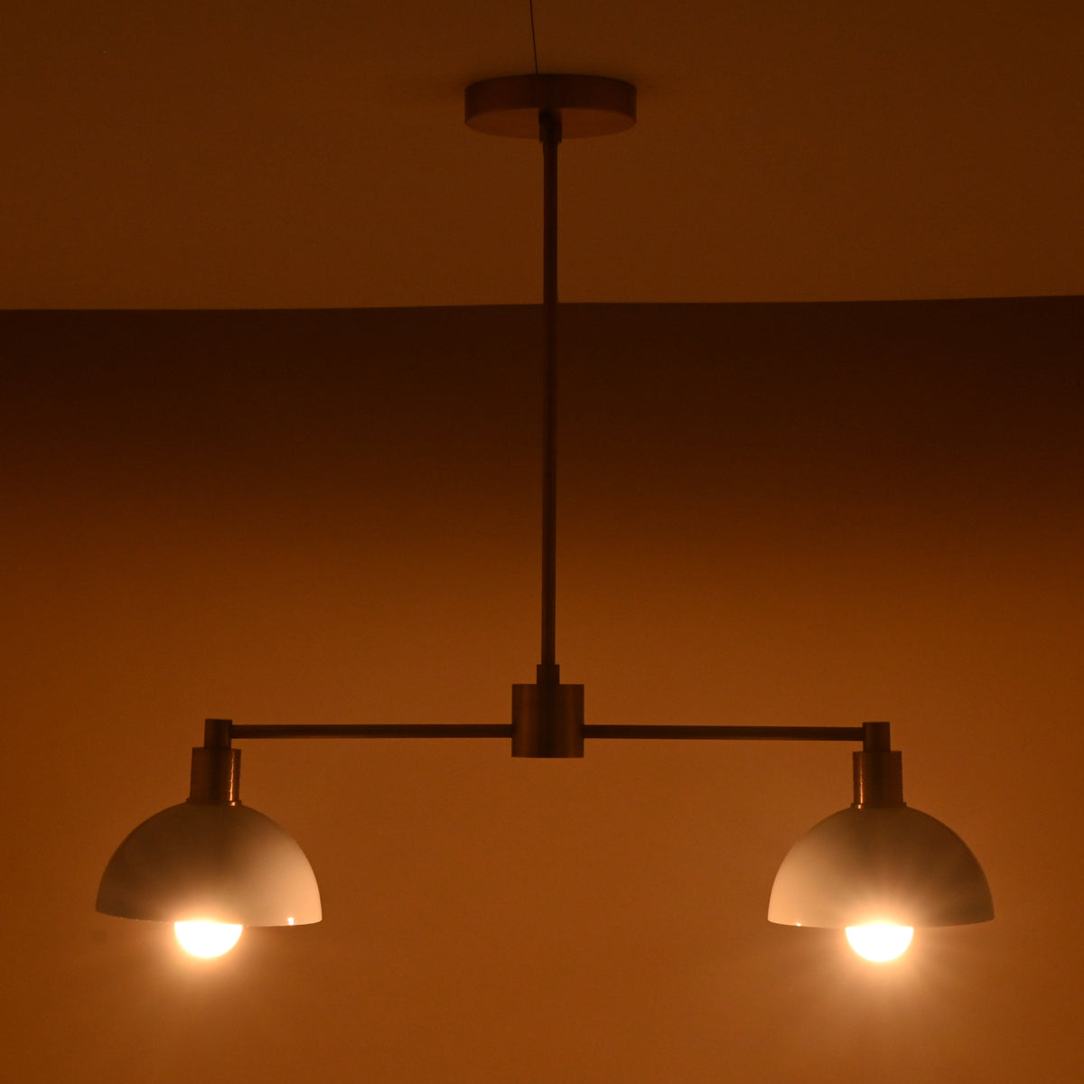 Two-light modern ceiling fixture in brushed brass and white dome shades, handcrafted for warm ambient lighting