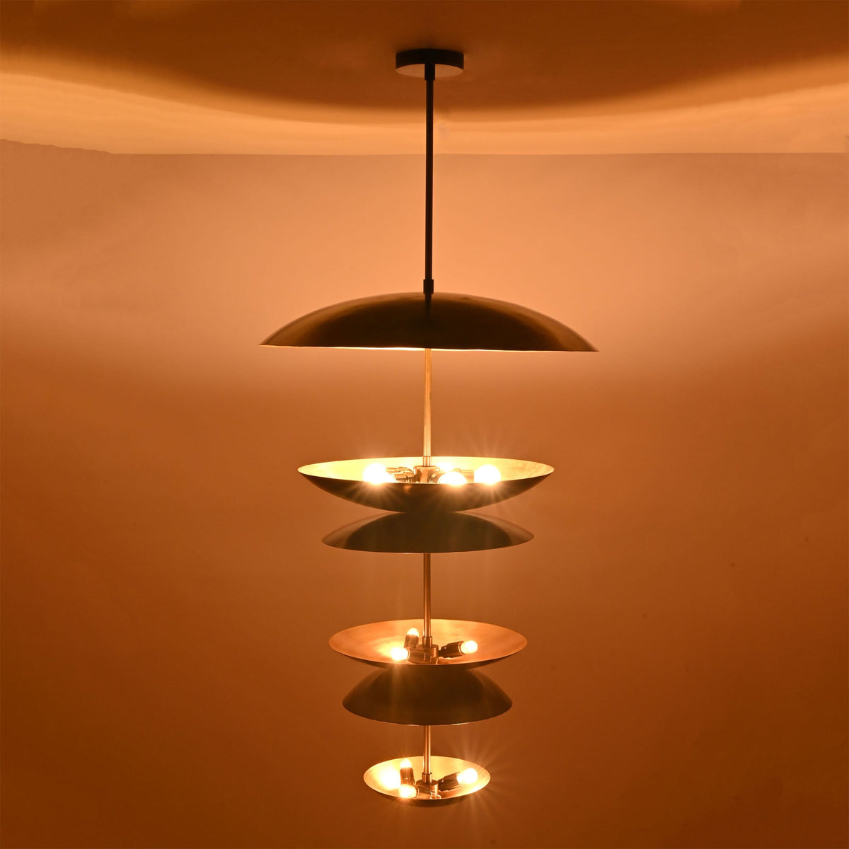 Close-up illuminated view of Eclipse Cascade Chandelier showcasing sculptural multi-tier dish shades