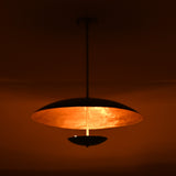 Warmly lit emerald green brass chandelier casting soft golden ambient light across ceiling interior