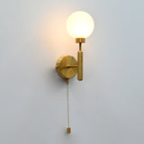 Illuminated raw brass globe wall sconce with round frosted globe, vertical stem, circular backplate, and pull chain.