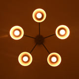 Symmetrical bottom view of five-light brass chandelier highlighting circular cone shades and warm central glow.