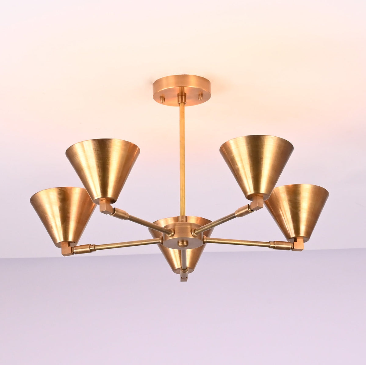 Minimalist five-light brushed brass chandelier with smooth cone shades and premium handcrafted brass finish.