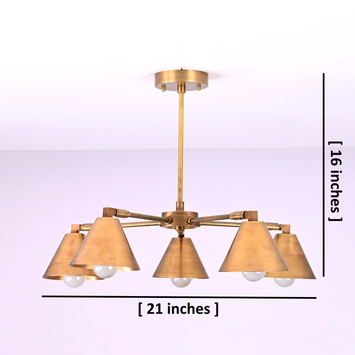 Five-light brushed brass chandelier showing 21-inch width and 16-inch height dimensions with cone-shaped shades.