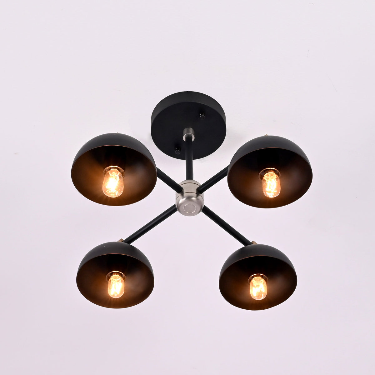 Bottom view of four light brass bowl ceiling fixture showing symmetrical layout and warm ambient illumination.