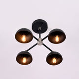 Bottom view of four light brass bowl ceiling fixture showing symmetrical layout and warm ambient illumination.