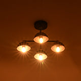 Four light brass ceiling chandelier producing rich warm glow and dramatic lighting effects in dark room.
