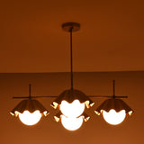 Wide linear view of four-light brass chandelier producing warm, diffused ambient illumination.