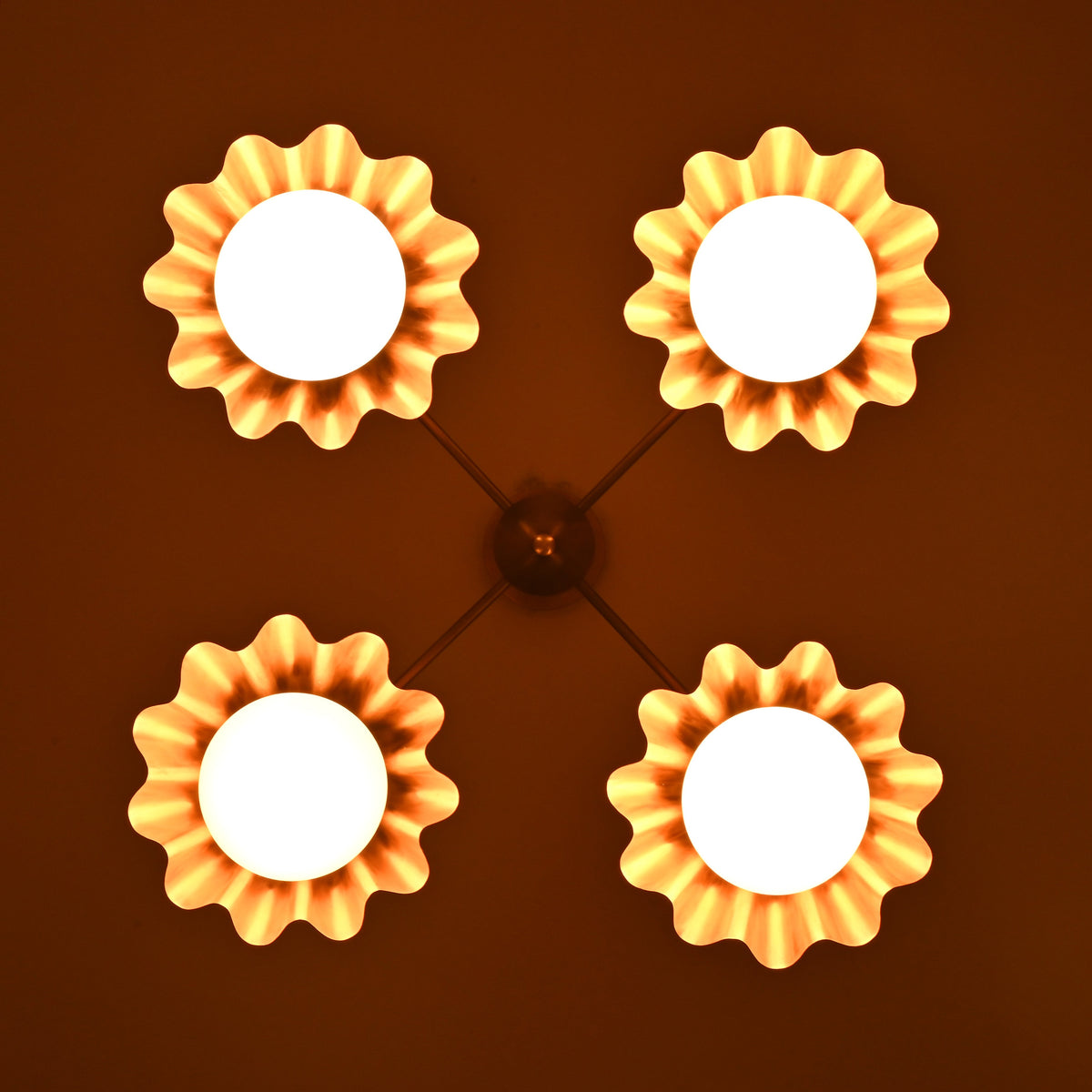 Four-light brass chandelier illuminated in low light, creating a warm ambient glow.