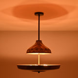 Handcrafted copper disc chandelier enhancing warm interior ambience with indirect brass lighting