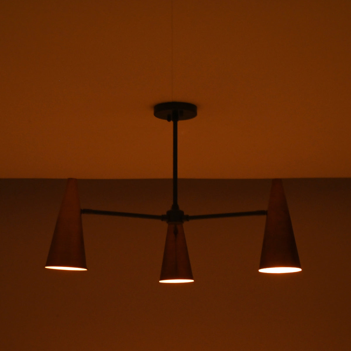 Close-up of handcrafted copper cone shade showing smooth finish and warm interior glow