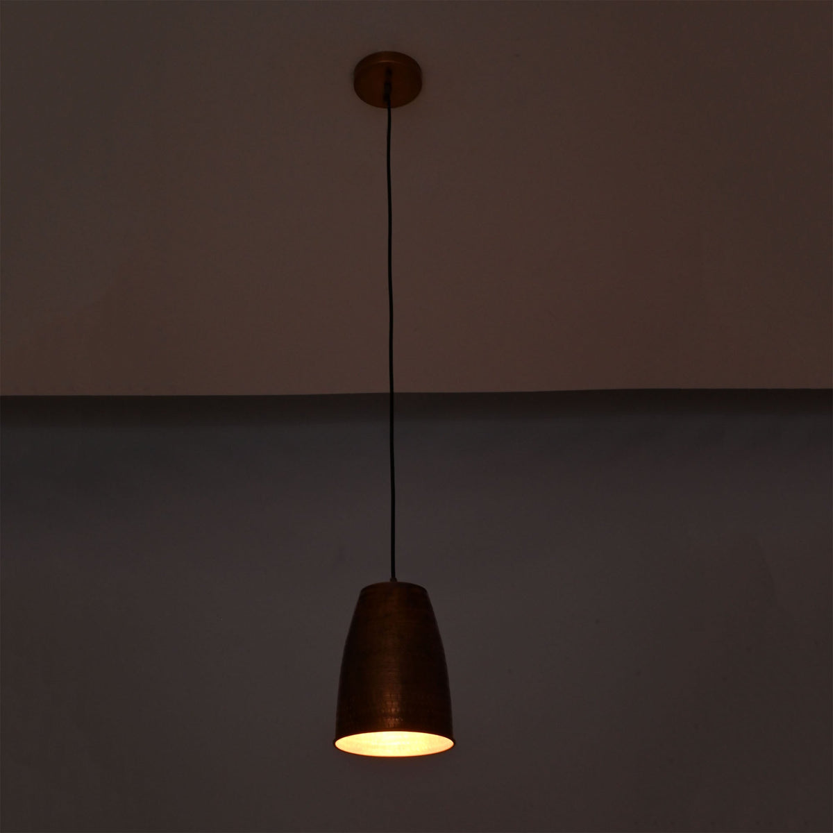 Hudson Hammered Copper Bell Pendant Light displaying warm ambient illumination with handcrafted hammered copper finish.