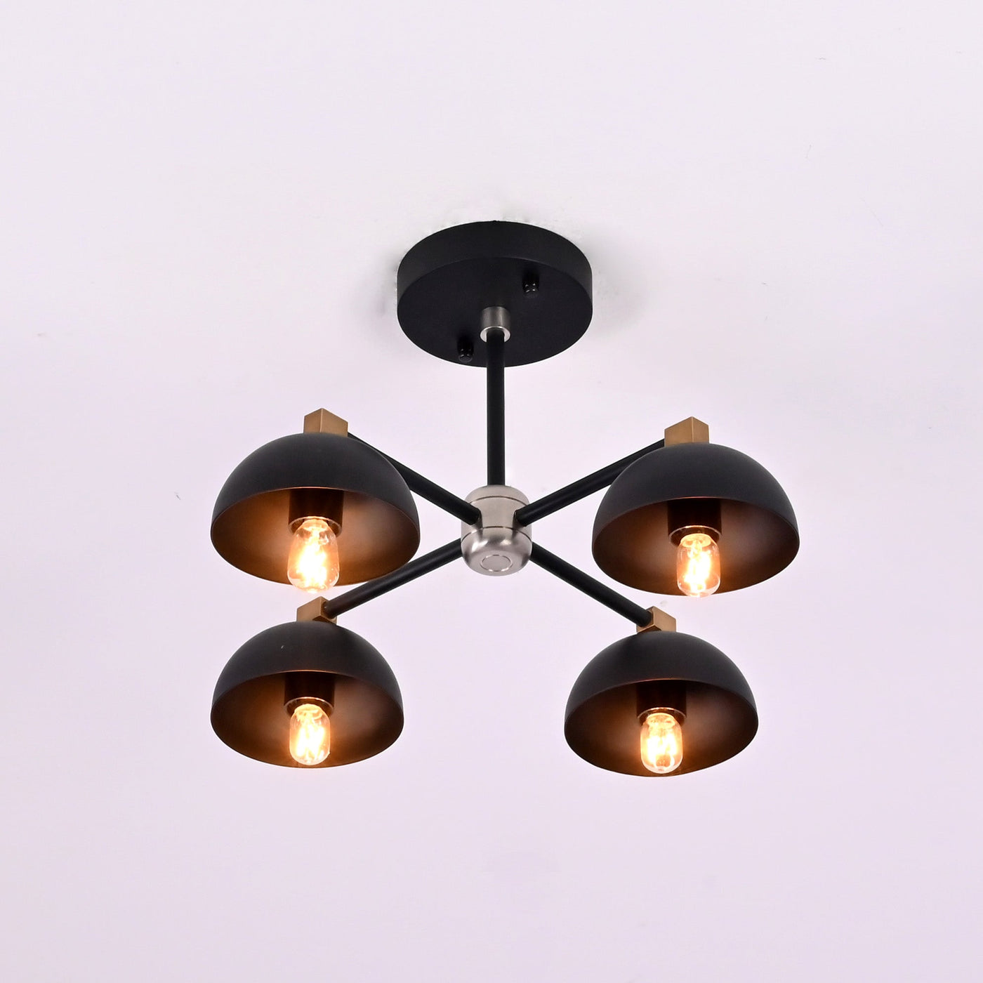 Side angle view of handcrafted brass bowl ceiling light showing industrial arms and warm indirect lighting.