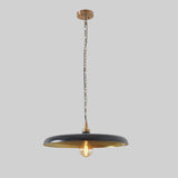 Interior view of dome pendant lamp with green enamel finish and warm glowing bulb