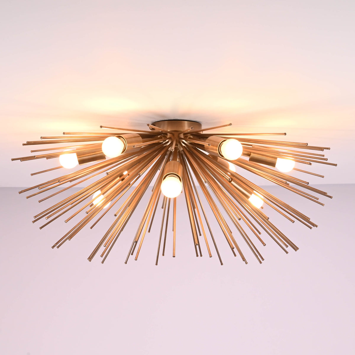 Low profile mid century starburst brass ceiling light emitting warm ambient illumination
