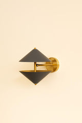 Angled view of handcrafted brass wall sconce with dual cone shades in matte black finish and warm brushed brass detailing.