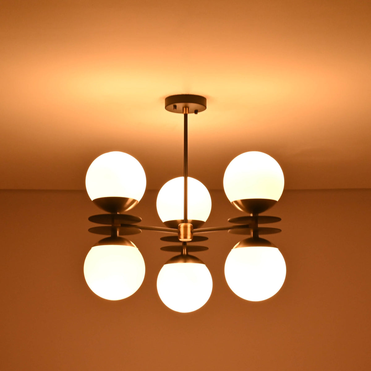 Luxury brass disc chandelier with opal globes emitting soft warm illumination