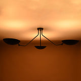 Elegant matte black brass ceiling light glowing softly in modern minimalist interior setting
