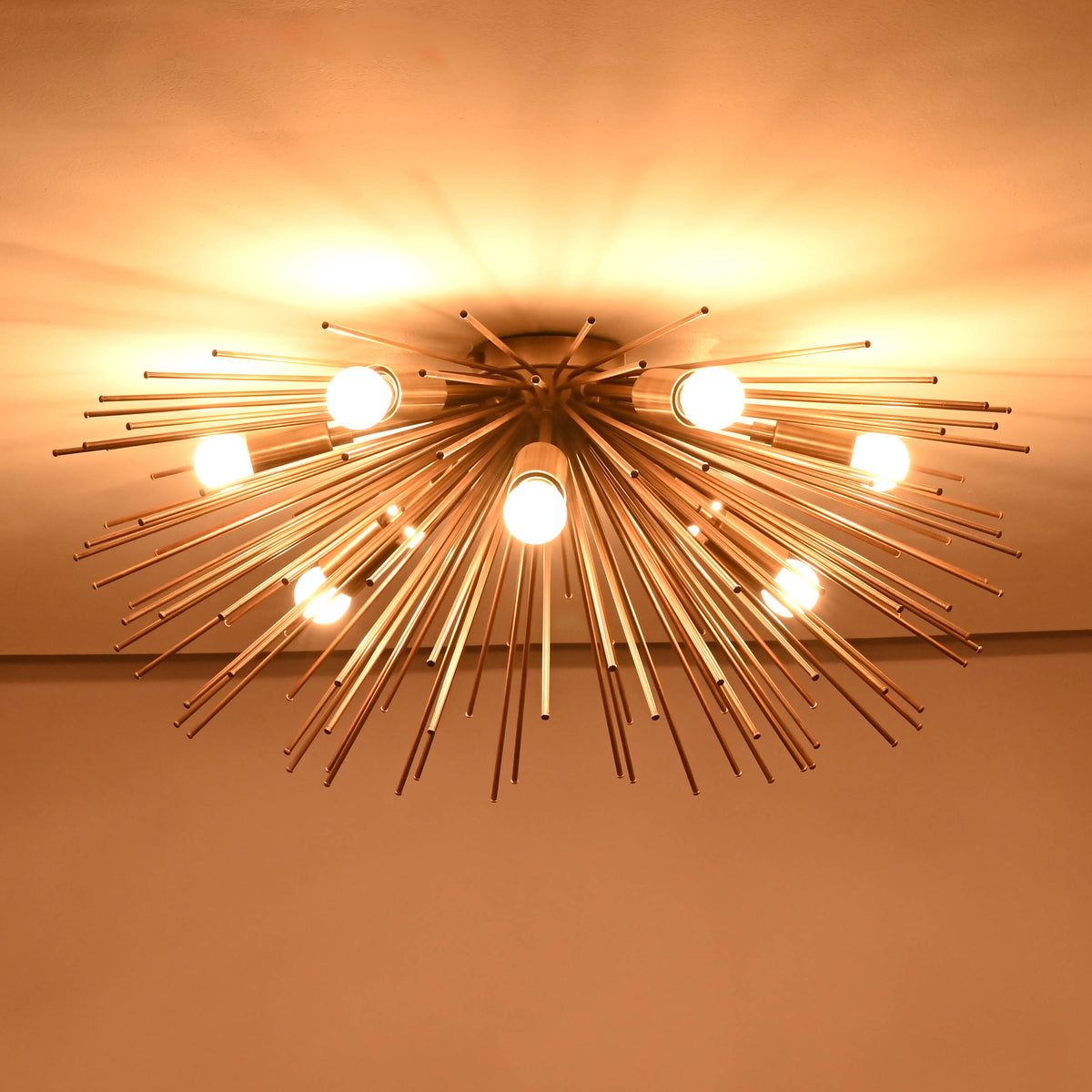 Mid century brass starburst chandelier fully illuminated with dramatic sculptural radiance