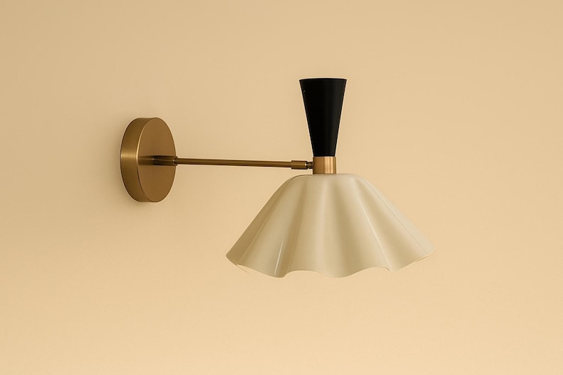 Mid century modern brass wall lamp with curved fluted shade and round backplate in brushed brass finish
