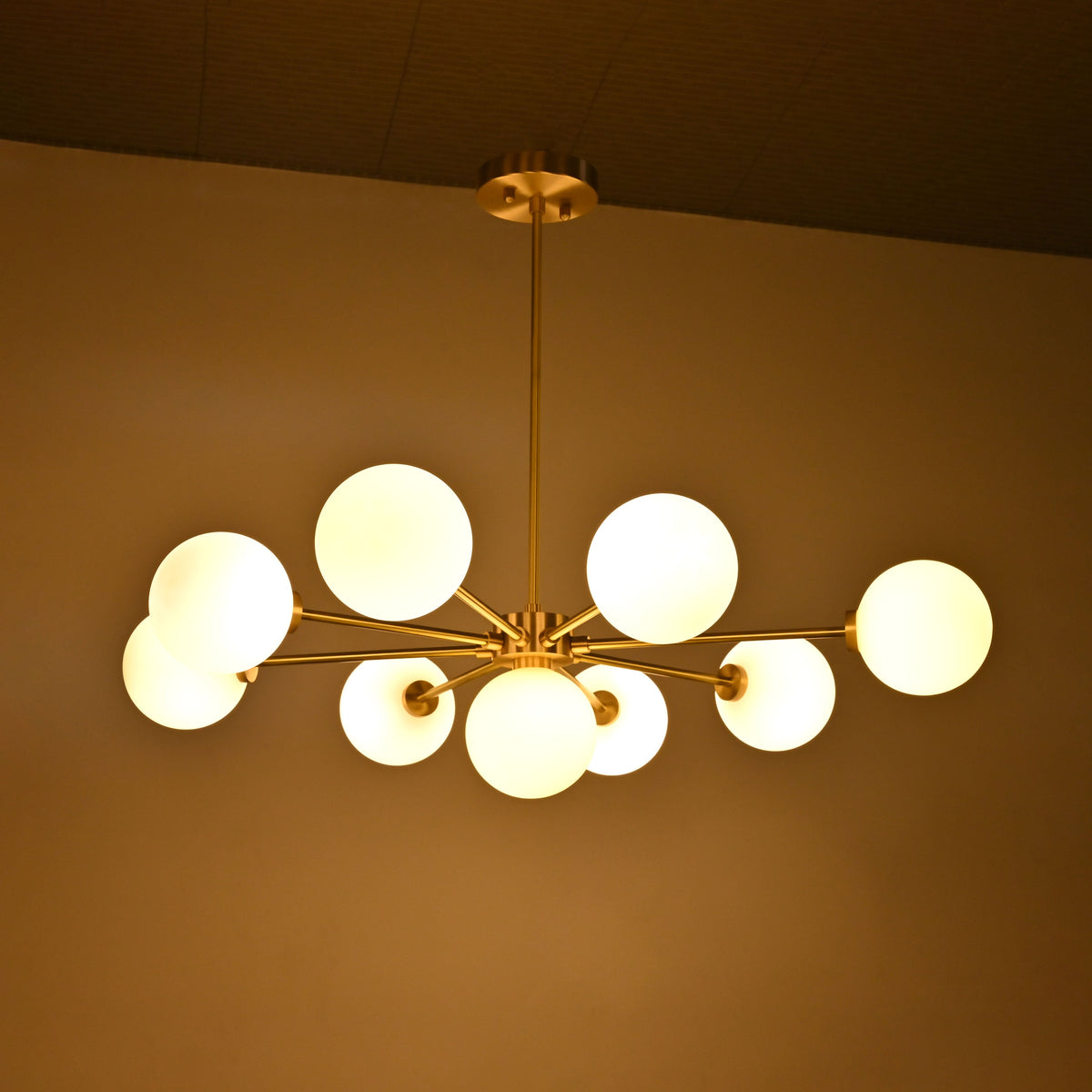 Mid century style glass globe Sputnik light with radial brass arms and warm white globe shades