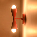Side mounted Milan Modern Double Cone Wall Sconce installed on wall with warm ambient illumination