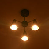 Bottom view of minimalist cone chandelier with three warm glowing lights