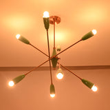 Mint green sputnik chandelier casting warm ambient light across the ceiling in a dark setting.