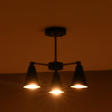 Modern three light cone chandelier fully illuminated showing warm focused light distribution