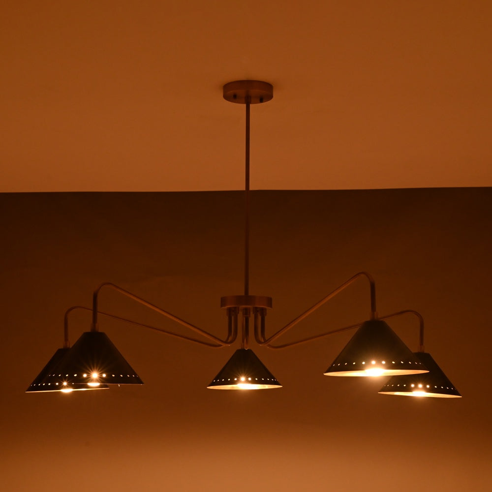 Night view of modern 5-light brass cone chandelier with perforated detailing and warm golden illumination.