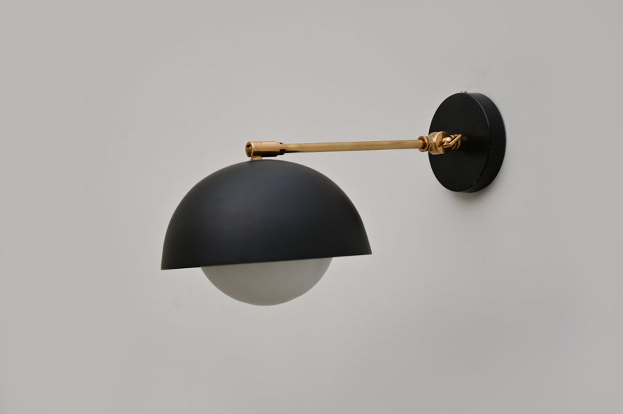 Side view of black dome wall light with brushed brass arm and matte black round mount, handcrafted by Brass Leaf Studio.