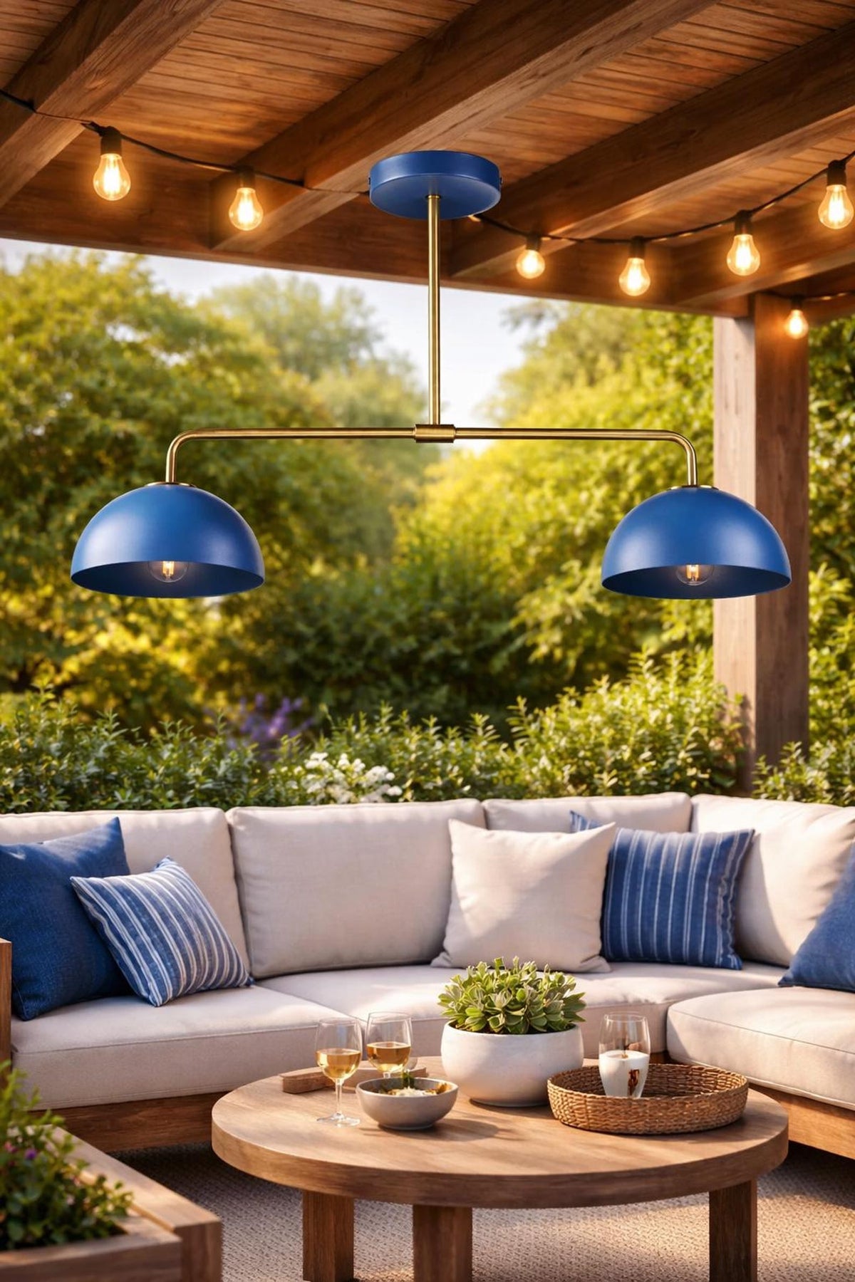 Contemporary blue double dome brass pendant light under wooden pergola with warm ambient lighting.