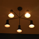 Close view of 5 cone brass chandelier showing warm light diffusion through metal cone shades