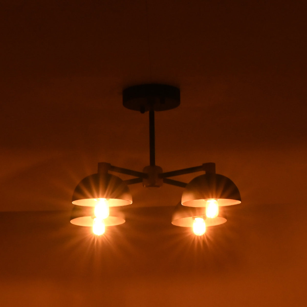 Modern brass bowl ceiling light illuminating space with warm indirect light during nighttime setting.