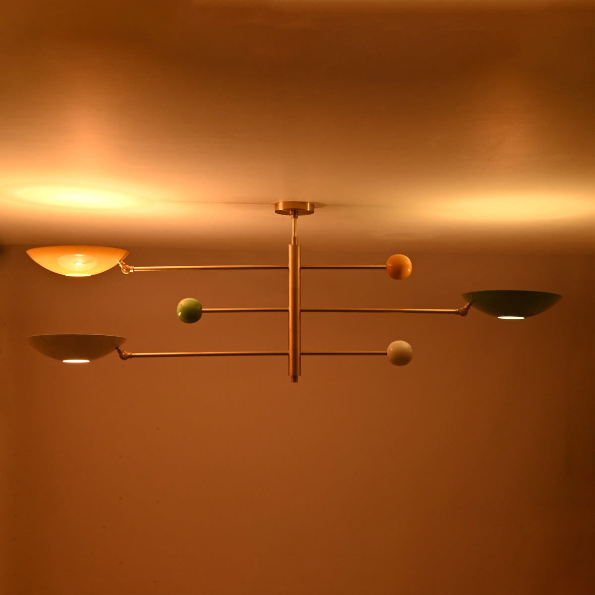 Modern brass flush mount ceiling fixture creating soft evening illumination with multicolor bowl shades